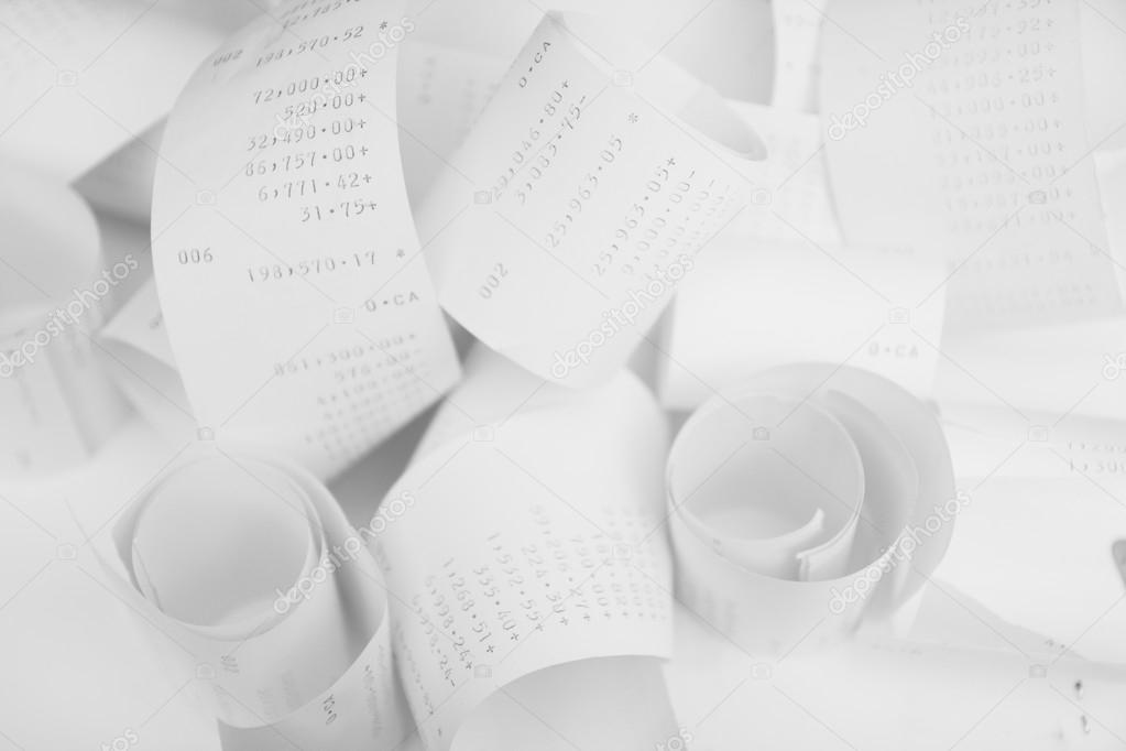 Paper cash register receipts in a lose pile close up with soft f