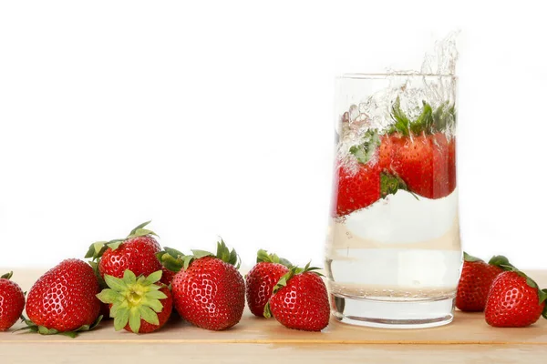 Fresh strawberry with soda splash and strawberries group on wooden board isolated on white background. Healthy fruits concept.