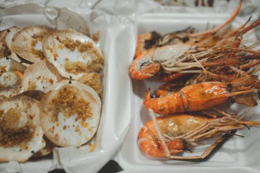 Köpük paketinde ızgara karides ve ızgara deniz tarağı. Tayland deniz ürünleri.