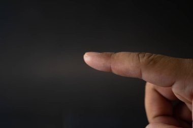 Siyah bir arkaplanda insan parmağı noktasını kapat