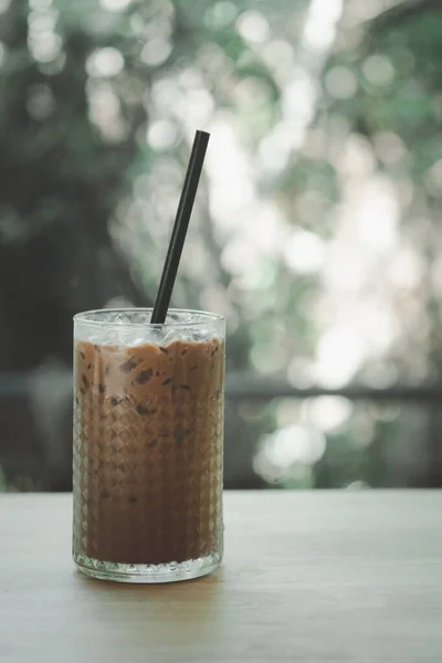 A glass of iced coffee Mocha with black straw on the table