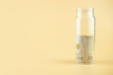 Tayland parası. Cam şişede 1000 Tayland Baht banknotu. Finans yatırımı ve günü kurtarma kavramı.
