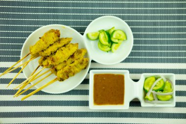 Fıstık soslu domuz eti ve salatalık dilimleri ve soğanlı turşu. Tayland yemeği.