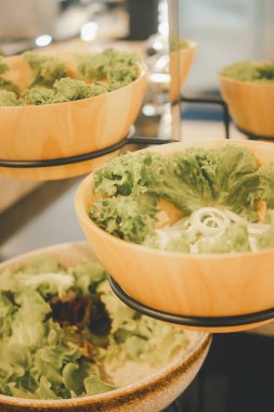 Otel restoranında sebze salatası büfesi. Tahta kasede taze sebzeler