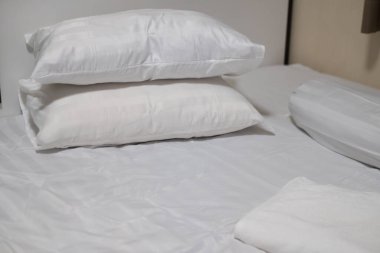 Kapalı beyaz çarşaf ve beyaz havluyla yastık. Yeni yatak kavramı