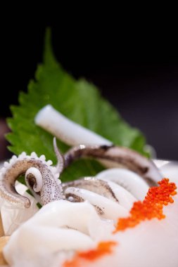 Üstte kalamar sashimi ve somon yumurtası. Japon yemeği. Seçici odak