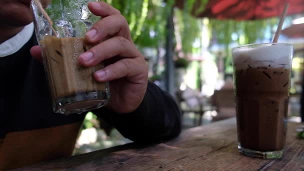 Unge Man Dricker Ett Glas Iskaffe Från Ett Papperssugrör Caféet — Stockvideo