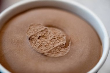 Buzdolabından yeni çıkmış çikolatalı dondurmalı kağıt bardak. Kapat.