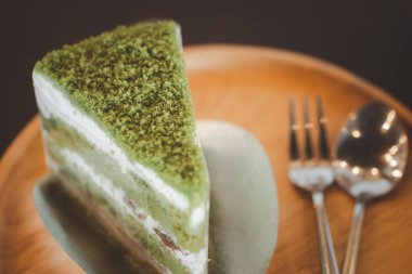 Yeşil çay ve kırmızı fasulye keki, tatlı yemek kaşıkla ve çatalla ahşap tepside.