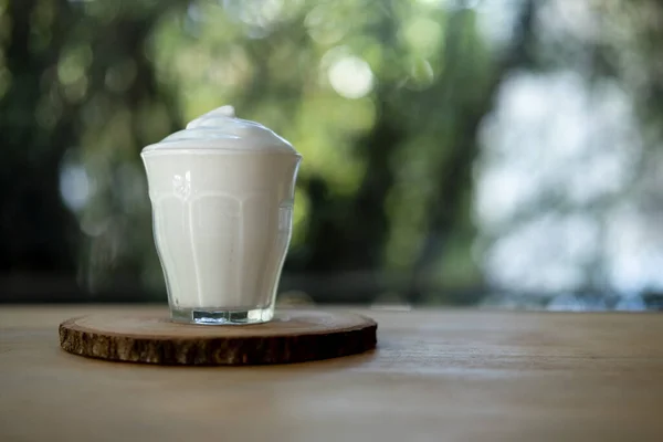 Espuma Leche Vaso Pequeño Sobre Platillo Madera Con Fondo Natural —  Fotos de Stock