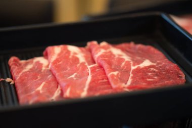 Restorandaki siyah tepside Shabu Shabu için dilimlenmiş Wagyu eti.
