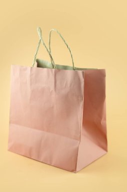 Sarı arka planda geri dönüştürülmüş pembe kağıt poşet