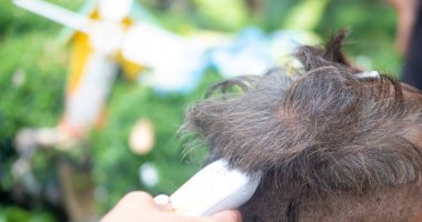 Kuaför yaşlı adamlar için şık bir saç kesimi yapıyor, karantina sırasında evde servis yapıyor.