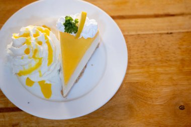 Bir dilim limonlu cheesecake ve krem şantili çikolatalı bisküvi..