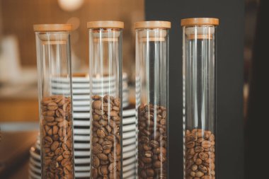 Kafenin dekorasyonu için cam şişede çeşitli kahve çekirdekleri var.