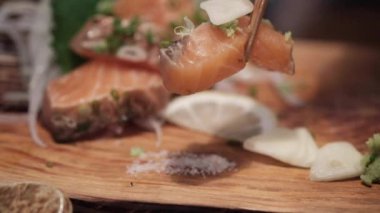 Erkek eli çubuk kullanır taze ve çiğ somon yanığı yer. Yavaş çekim