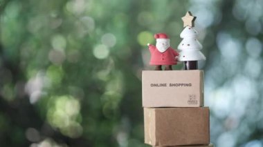Santa Costa ve Noel ağacı dükkanının karton kahverengi kutunun üzerinde çevrimiçi alışveriş. Noel ve yeni yılda e-ticaret kavramı
