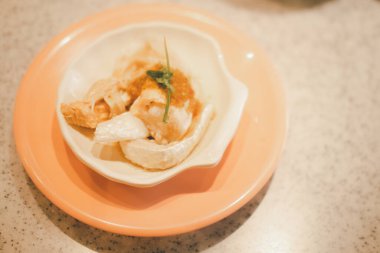 Kabuklu deniz hayvanı şeklinde haşlanmış somon derisi. Kapat.