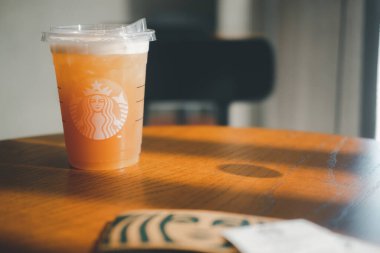 Samut Prakan, Tayland - 12 Ocak 2021: Bir bardak buzlu Manuka Bal Zencefilli Zencefilli Zencefil çayı, Ocak 2021 'de Starbucks' taki kahvecinin ahşap masasındaki yeni içecek.