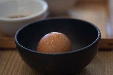 Malzeme yemeği için siyah kasede taze yumurta.