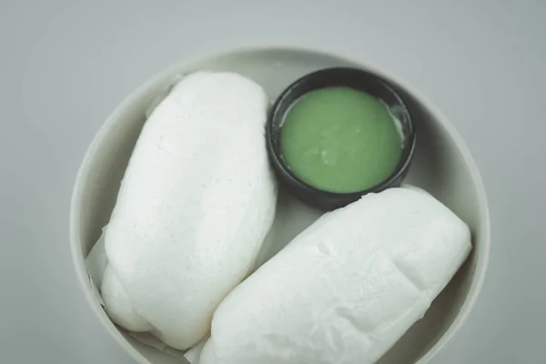 Chinese steamed bread mantou served with  pandan custard is a common dipping sauce for fresh breads of all sorts