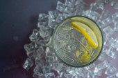 Sklenice s nápojem s citronem a ledem na ledových kostkách umělé křišťálové pozadí