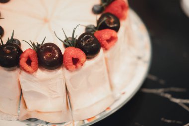 Taze ahududu ve taze böğürtlenli kremalı pasta süslemesi.