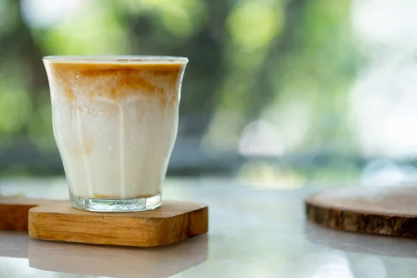澄んだガラスの中で提供されるダーティコーヒーメニューというミルクコーヒーのカップ — ストック写真