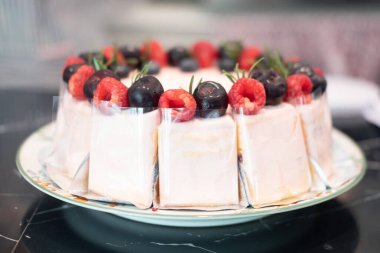 Taze ahududu ve taze böğürtlenli kremalı pasta süslemesi.