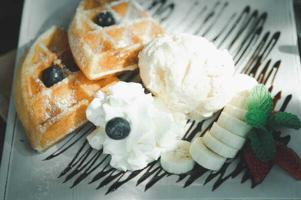 Fresh waffles with ice cream served with banana and strawberry. Food and dessert concept