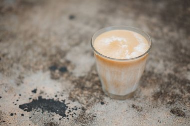 Kahve masasında kirli desenli Dirty Latte kahvesini kapat. Buzlu sütle, bardakta serpiştirilmiş espresso arasında oldukça açık bir şekilde servis ediliyor..