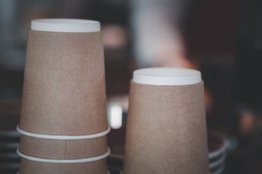 Kahverengi bardaklar dolusu tek kullanımlık kağıt bardaklar kahve makinesinin üzerinde.