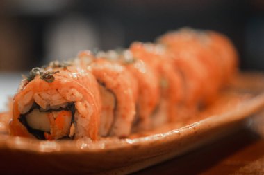 Yanmış somon suşi rulosu. Taze ve lezzetli Japon suşisi. Seçici odak