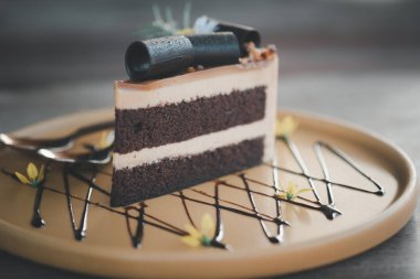 Kahve dükkanındaki sarı tabakta bir parça moka keki.