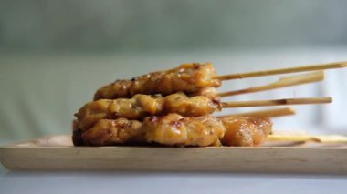 Tayland usulü tavuk ızgara şişler ahşap tepside yavaşça döner..