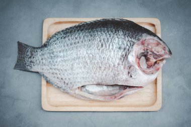 Tahta tepside pişmeye hazır Tilapia balığı. Bu yemek.