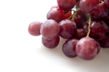 Beyaz arka planda bir sürü taze kırmızı üzüm.
