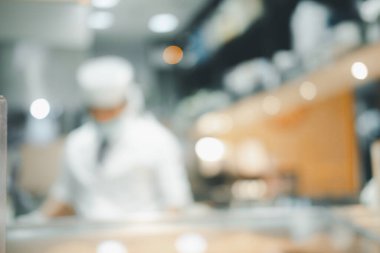 Görüntü şefi mutfak tezgahında yemek pişiriyor ve arka plandaki müşterilere servis yapıyor. Japon Omakase Restoran Sayacı