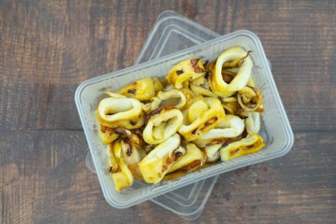 Tahta masadaki plastik kutuda Tayland usulü yemek dilimleri. Götürme kavramı