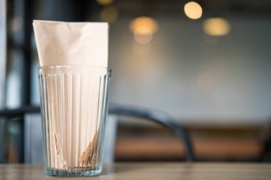 Restorandaki ahşap masadaki bardaktaki mendiller.