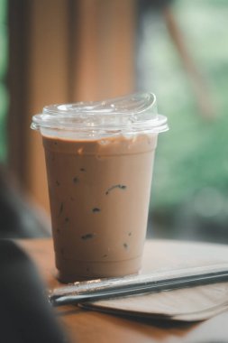Ahşap masada plastik bardakta buzlu kahve..