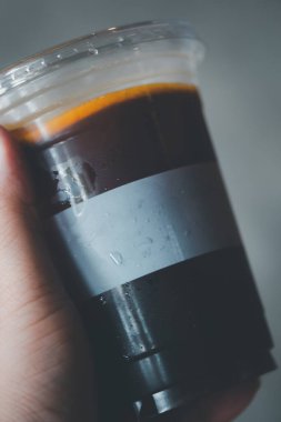 Donmuş americano dilimlenmiş portakalla kaplanmış plastik bardaklar. 