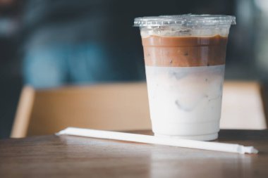 Lokantada ve kafede ahşap masada plastik bardakta buzlu kahve.