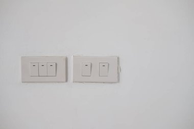 Beyaz duvardaki beyaz elektrik açma kapama düğmesi. Modern elektrik düğmesi