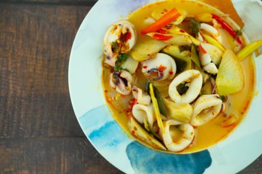 Tom Yam (Tayland yemeği) kalamar, kaffir kireç yaprakları, galangal, kişniş yaprakları, seramik kadehte saman mantarları, üst manzara