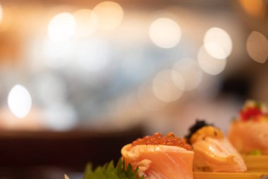 Bokeh arka planında somon yumurtası ile kaplanmış rulo somon üzerine seçici odaklanma