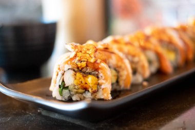 Somon balığı Engawa siyah taşın üzerinde yuvarlanıyor. Somon Suşi 'ye yakın çekim.