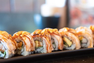 Bulanık bir arka planda somon peyniri rulosu - Japon yemek tarzı