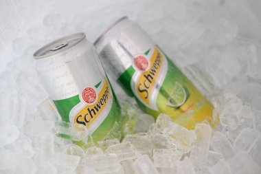 Bangkok, Tayland - 28 Şubat 2021: Buz sepetinde iki kutu alüminyum Schweppes manao soda, 1870 yılında tanıtılan popüler karbonatlı sular.