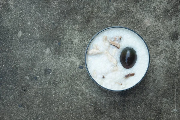 Close up of preserved egg porridge in bowl. Top view